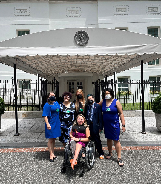  A group of people standing in front of a White House entrance wearing formal attire