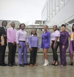 8 Members pose together wearing purple.