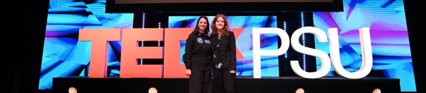 Natalie Meriwether and Renee Frohnert stand and smile together on the TEDxPSU stage.
