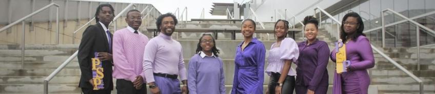 8 Members pose together wearing purple.